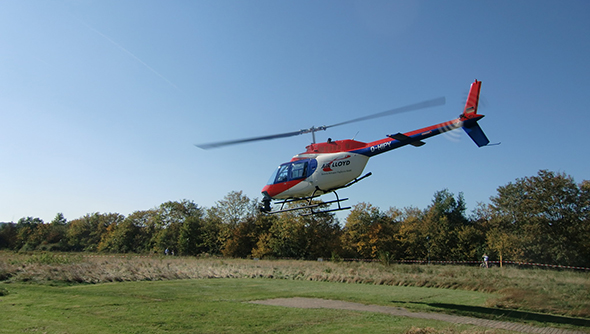 Ein Foto eines Helikopters bei der Kontrolle des Hochspannungsnetzes.